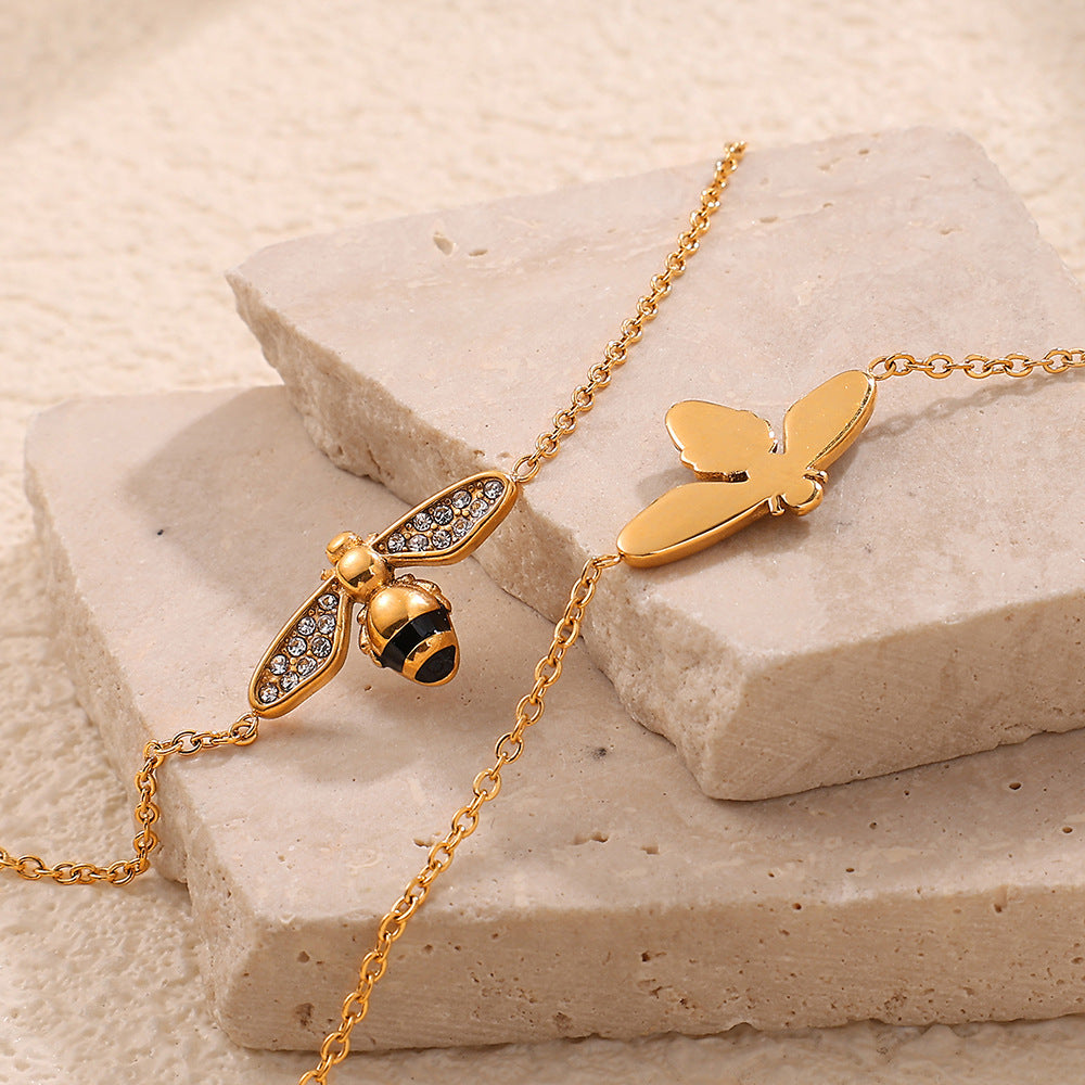 Gold bee-shaped bracelet on a stone surface