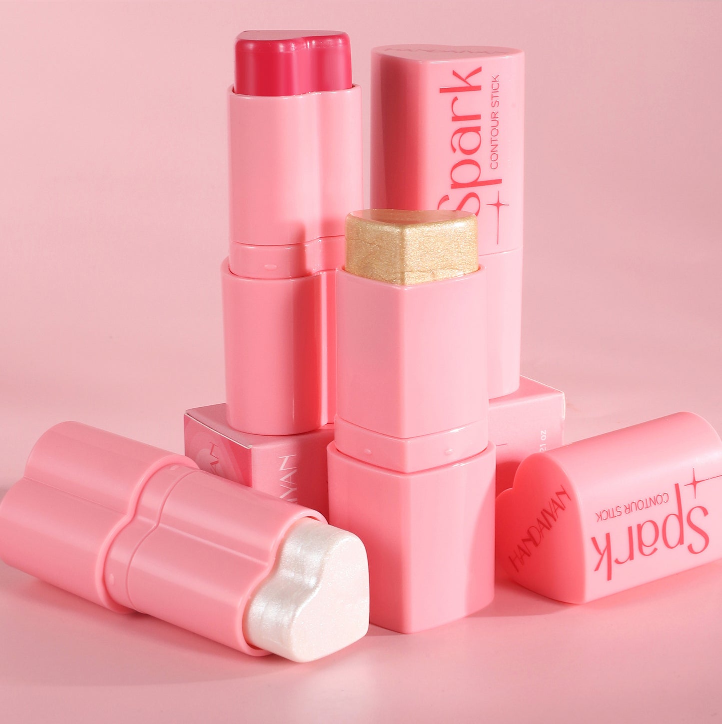 Pink makeup stick with 'Spark' branding on a pink background