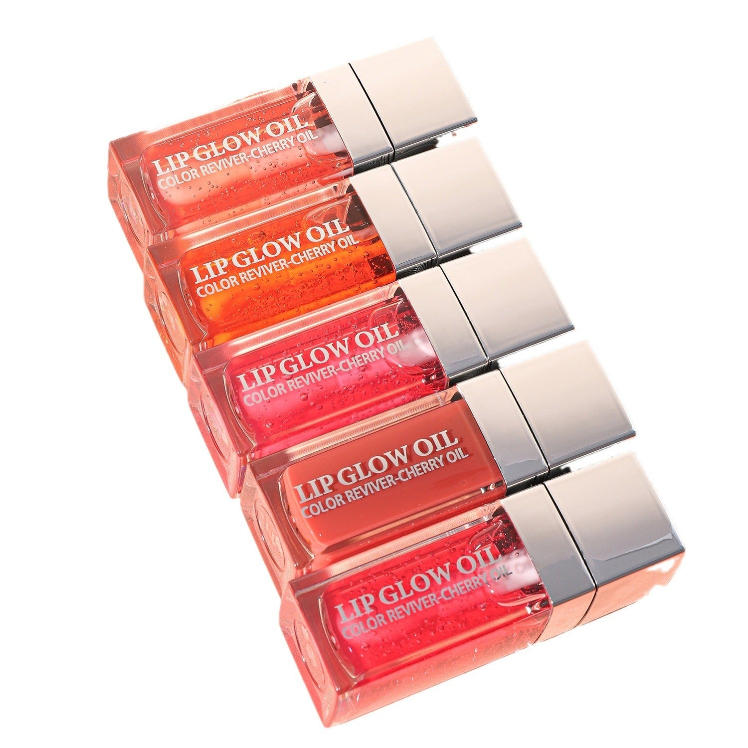 Stack of lip glow oils with visible labels on a white background