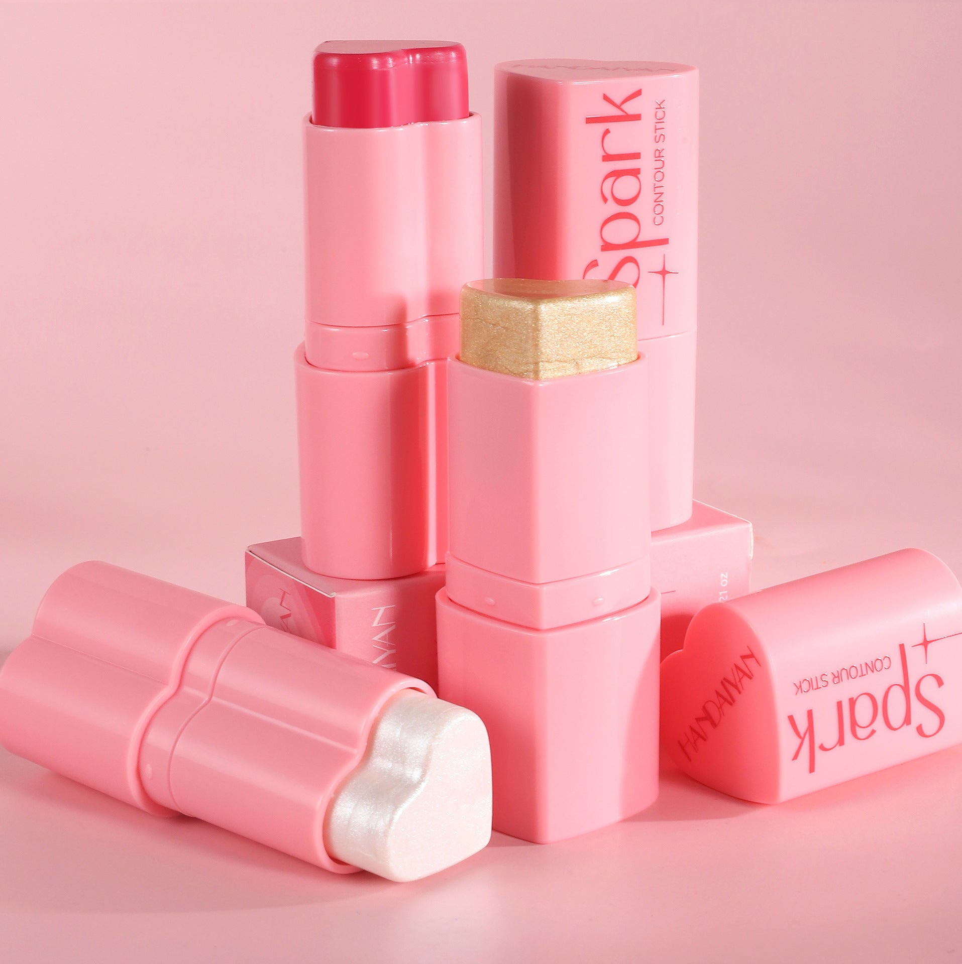 Pink makeup stick with 'Spark' branding on a pink background